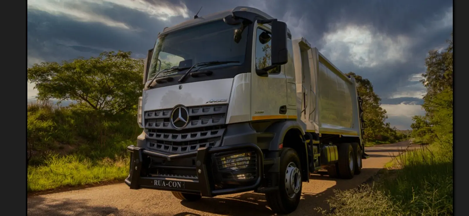 Rua-Con compactor truck under a dramatic sky