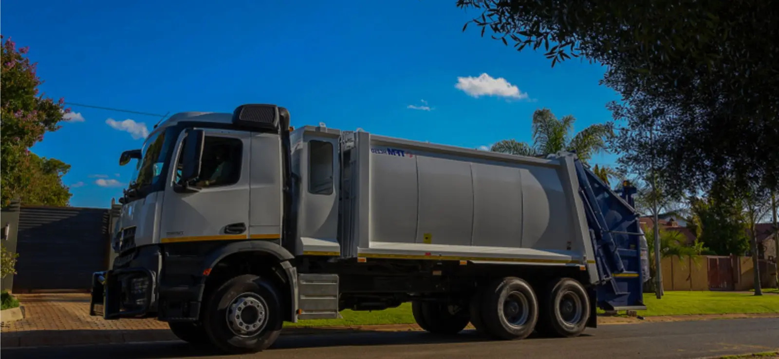 Rua-Con refuse compactor truck in branded livery parked on a residential street